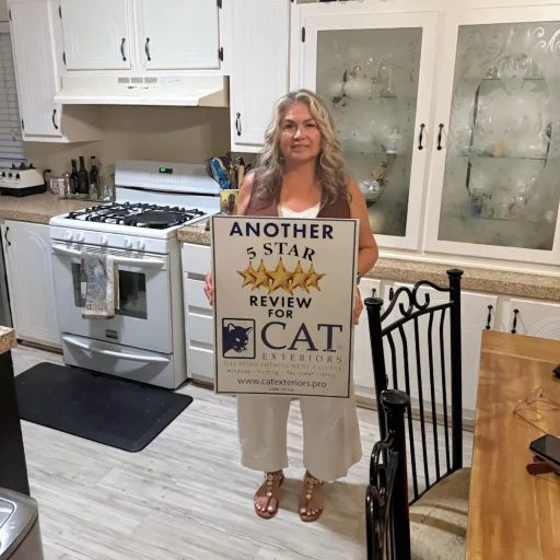 A full color 1080x1080 webp image of a happy CAT Exteriors client in front of their home.