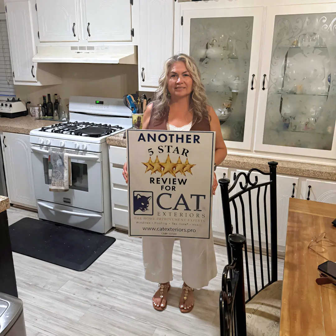 A full color 1080x1080 webp image of a happy CAT Exteriors client in front of their home.