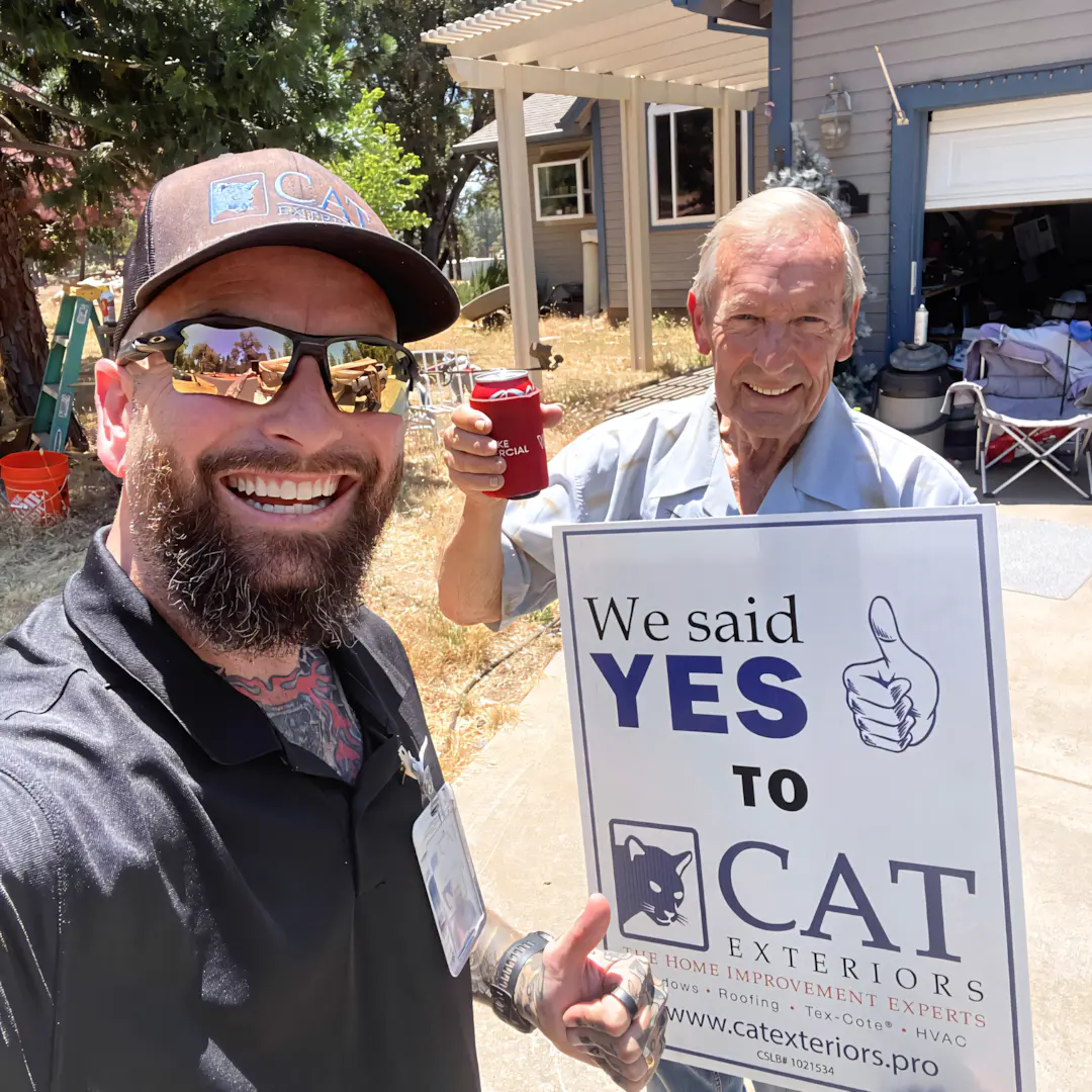 A full color 1080x1080 webp image of a CAT Exteriors representative taking a photo with a happy client at their home.