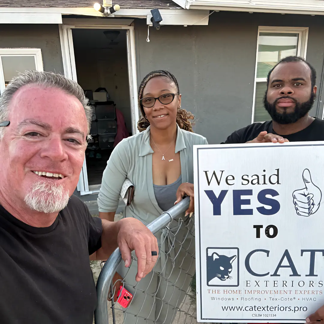 A full color 1080x1080 webp image of a CAT Exteriors representative taking a photo with a happy client at their home.