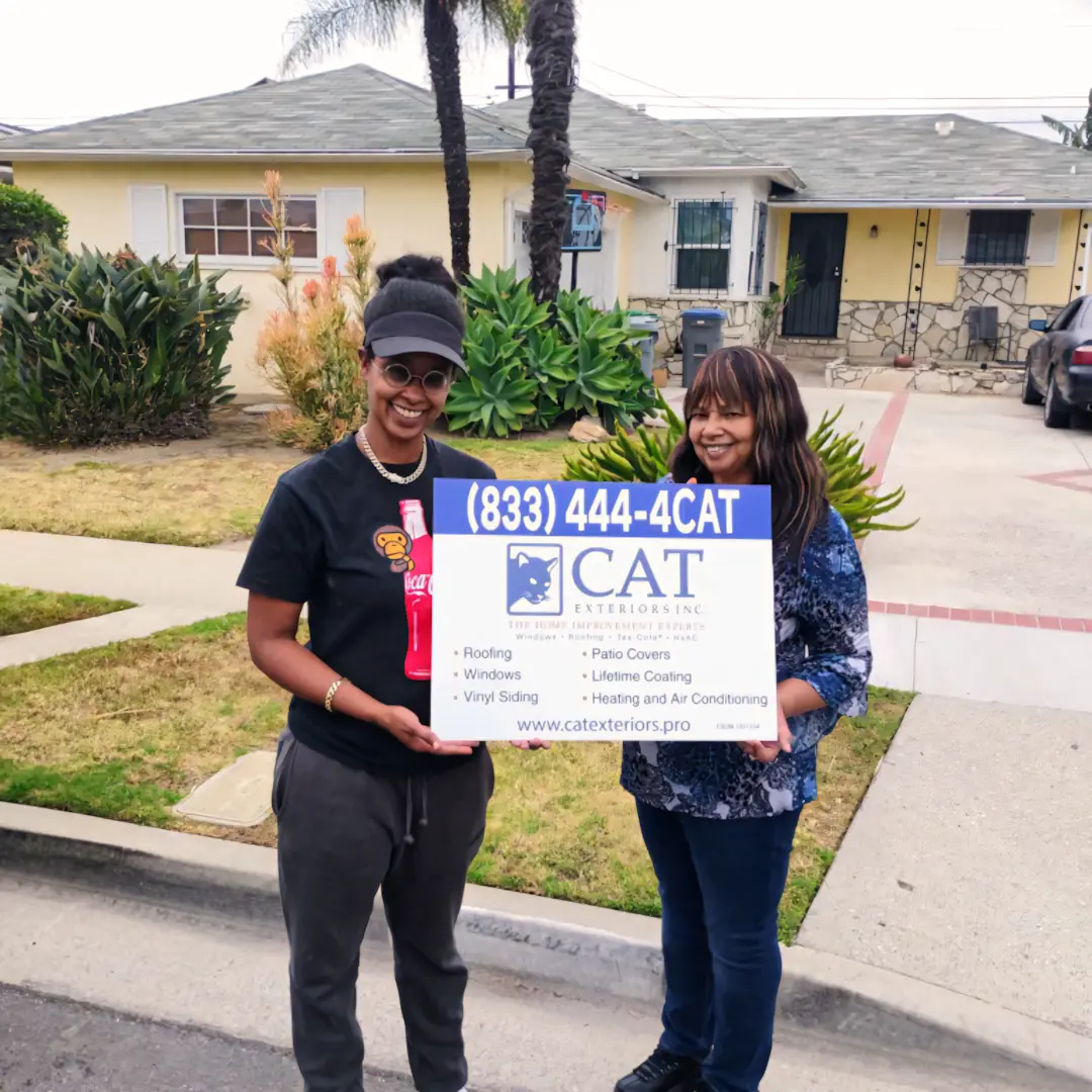 A full color 1080x1080 webp image of a happy CAT Exteriors client in front of their home.