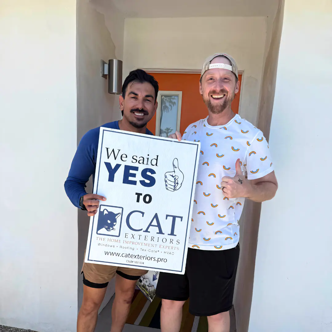 A full color 1080x1080 webp image of a happy CAT Exteriors client in front of their home.