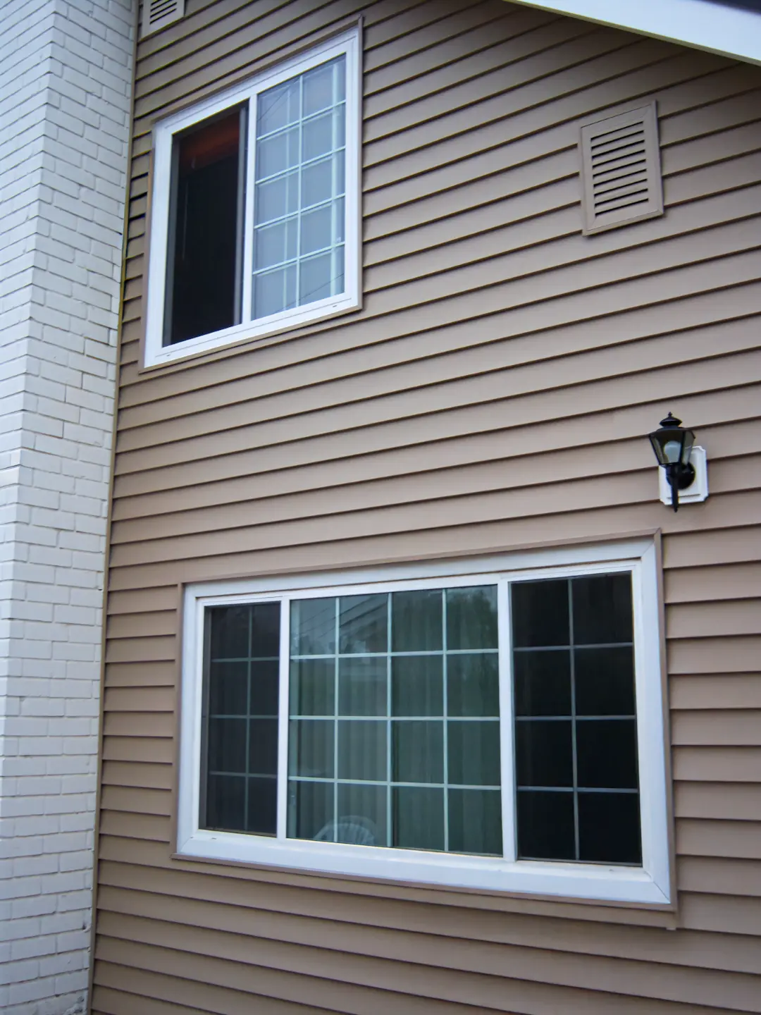 A full color 1080x1440 webp image of a CAT Exteriors completed vinyl siding installation on a residential home.